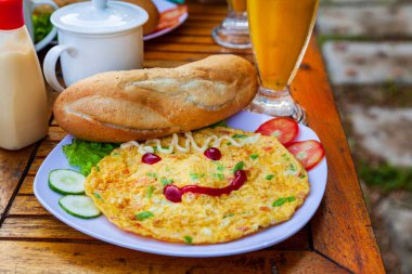 Çırpılmış yumurtalı kahvaltı, neşeli kahvaltı, ketçaplı omlet, ekmek, sebze salatası.