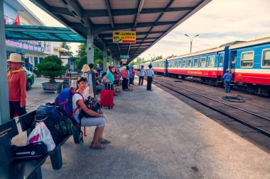 Hue, Vietnam, 26 Haziran 2019 Vietnam tren istasyonu, istasyon çalışanı biletleri kontrol ediyor, yolcular treni bekliyor.