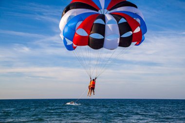 Hoi An, Vietnam, 28 Haziran 2019: Hoi An 'ın merkez plajı, açık hava aktiviteleri, paraşütle atlama, denizde sürat teknesiyle renkli bir paraşütle uçan paraşüt..