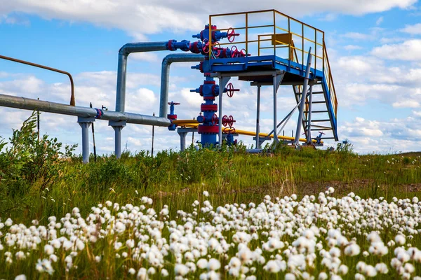 Oil, gas industry. Group wellheads and valve armature, Gas valve, Gas well of high pressure, against the blue sky with clouds,