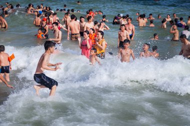 Cat Ba Adası, Vietnam, 19 Haziran 2019: Cat Ba Adası, Cat Co 3 plajında birçok Çinli turist, pahalı Cat Ba Sunrise Resort 'un yanındaki dalgalarda yüzüyor.