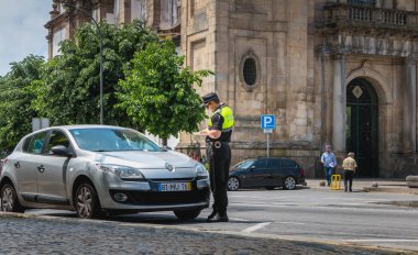 Braga, Portekiz - 23 Mayıs 2018: polis denetler ve bir bahar gününde bir araba şehir merkezinde trafik cezası yazıyor