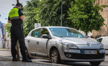 Braga, Portekiz - 23 Mayıs 2018: polis denetler ve bir bahar gününde bir araba şehir merkezinde trafik cezası yazıyor