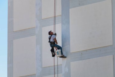 Sesimbra, Portekiz - 8 Ağustos 2018: ressam bir iple rappelling bir bina cephe aşağı geliyor