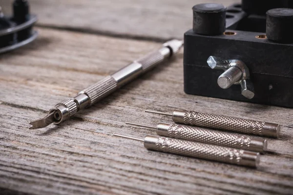 stock image Set of watchmaker tools isolated on a rough wooden board close up