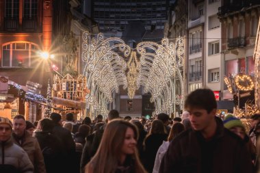 Mulhouse, Fransa - 23 Aralık 2017: mutlu insanlar, sıcak kış yürüyüş için geceleri belgili tanımlık Noel çarşı içinde bir kış gününde giyinmiş