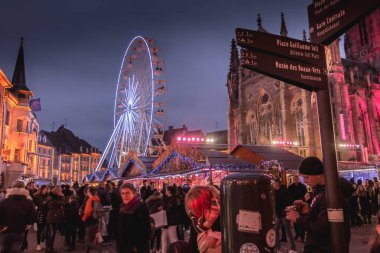 Mulhouse, Fransa - 23 Aralık 2017: mutlu insanlar, sıcak kış yürüyüş için geceleri belgili tanımlık Noel çarşı içinde bir kış gününde giyinmiş