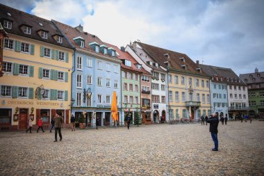 Bir Freiburg im Breisgau, Almanya - 31 Aralık 2017: insanlar giyinmiş sıcak bir kış gününde katedral döşeli meydanında yürüyüş