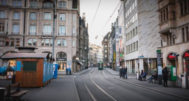 Basel, İsviçre - 25 Aralık 2017 - yolcu bir şehir merkezi istasyonunda bir elektrikli tramvay varışta bir kış günü bekliyor