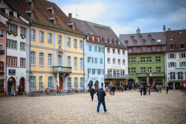 Bir Freiburg im Breisgau, Almanya - 31 Aralık 2017: insanlar giyinmiş sıcak bir kış gününde katedral döşeli meydanında yürüyüş