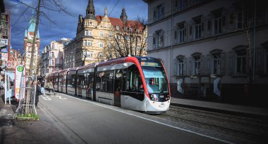 Bir Freiburg im Breisgau, Almanya - 31 Aralık 2017: elektrikli tramvay nereye yolcular kendi taşıma varış için beklemek bir kış gününde bir tramvay istasyonu geçen