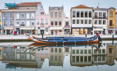 Aveiro, Portugal - May 7, 2018: Tourists walk on famous Moliceiros on a spring evening, traditional boats used to harvest seaweeds in the past clipart