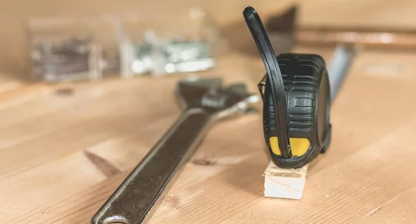 Hammer nails wrench and meter laid on a wooden stall — Stock Photo, Image