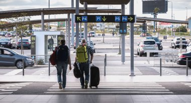 Faro otoparkında bavulları ile giden yolcular 