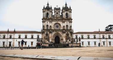 İnsanlar Alcobaca Manastırı, Portekiz önünde yağmurda yürümek