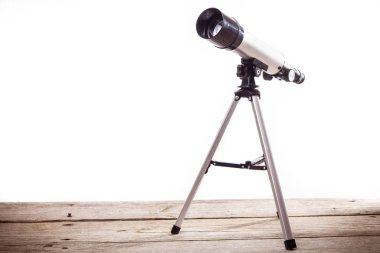 ahşap tahta üzerine döşenmiş beyaz bir arka plan üzerinde teleskop
