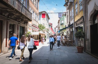 Sütyenler için dekore edilmiş tarihi şehir merkezinde yürüyen insanlar.