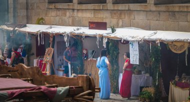 Kostümlü ve halktan insanlar tarihi şehir merkezinde tartışıyorlar.