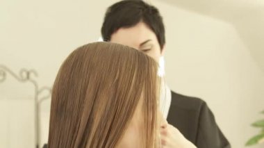 Bayan Kuaför tel saç kesme genç kadının Kuaför salonu önünde tarama. Güzellik salonunda kadın saç kesimi yapma haircutter kadar kapatın.