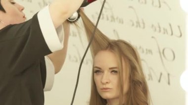 Sarışın kadın saç şekillendirme uzun saç kurutma makinesi ve kuaförlük salonda saç fırçası ile sırasında. Kadın saç kurutma makinesi ile kurutma haircutter yukarıya kapatmak ve çamaşır ve kesme sonra tarak.