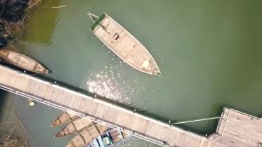 Tekne ayakta hava yeşil göl manzaralı ahşap iskele yakınında park yerinde. Ahşap tekneler nehir uçağı Park üzerinde göster.