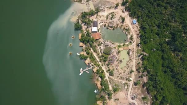 Drohnenblick Bootsanlegestelle und Bungalow zur Erholung am See inmitten tropischer Natur in den Bergen. Grünes Wasser in schöner Seenluftlandschaft. — Stockvideo