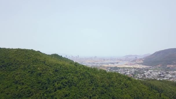 Vista desde montañas verdes a la ciudad moderna en vista aérea de distancia. Hermoso paisaje de volar drones verdes montañas en metrópolis muy lejos . — Vídeo de stock