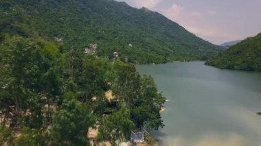 Güzel dağ nehir ve kıyı havadan görünümü üzerinde bina. Yeşil dağ dron yolda vur. Yeşil dağ ve drone kızartma üzerinden göl manzaralı.