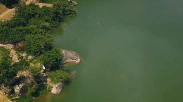 Grünes Wasser und große Steine am Ufer schöner See Luftaufnahmen von fliegenden Drohnen. Straße entlang des Flusses mit felsigem Ufer Drohnenblick. — Stockvideo