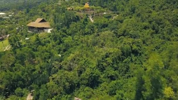 Green mountain with tropical forest and houses aerial view. Beautiful landscape buildings in high mountains covered tropical forest from flying drone. — Stock Video