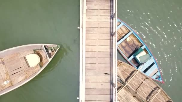 Drohnenboot steht auf Parkplatz in der Nähe von Holzsteg auf grünem See. Holzboote auf dem Parkplatz im Fluss Luftaufnahmen. — Stockvideo