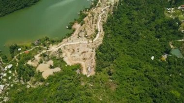 Sahil dağ Gölü ve yeşil orman yolda. Drone dağ yol ve yeşil tropikal ağaçların kıyısında uçan hava manzara fom.