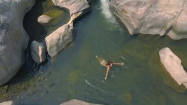 Genç kadın temiz su dağ nehir uçak uçan çekim hava yüzme. Mutlu kadın dağ şelale üstten görünüm şeffaf suda yüzen.