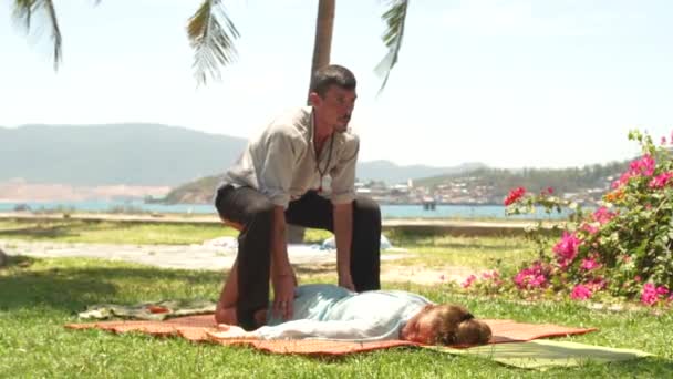 Man massagiste doing acupressure massage to woman outdoor. Thai acupuncture body massage. Treatment and rehabilitation concept. Eastern medicine. — Stock Video