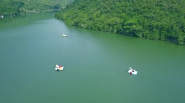 Yeşil dağ gölü suda yüzen Katamaran. Yaz tatili sırasında Katamaran güzel göl üzerinde sürme dron viewpeople. Uçak uçan üzerinden hava manzara.