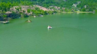 Dağ gölde yüzen hava manzara Katamaran. Yaz tatili sırasında Katamaran güzel göl üzerinde sürme dron görünümü insanlar. Su ulaştırma araçları yaz etkinliği.