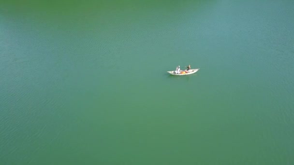 Älskare Rider i båt på sjön under sommar och semester. Lyckligt par kvinna och man tillsammans avkopplande på båten vatten. Personer roddbåt på gröna sjön. Antennen fotograferar från flygande drönare. — Stockvideo