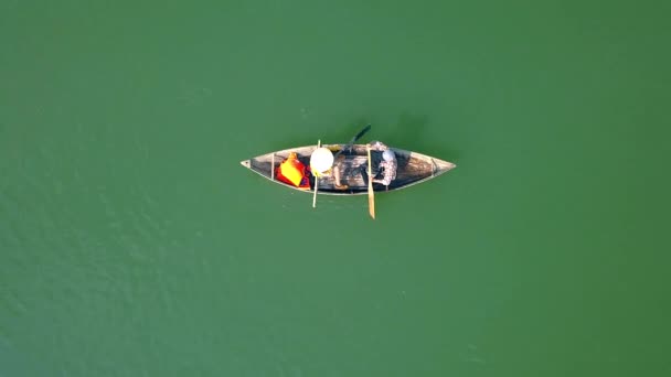 Мужчина и женщина катаются на лодке по озеру во время летних каникул. Счастливая пара плавает и отдыхает на лодке воды. Люди катаются на лодке по зеленому озеру. Воздушная стрельба из летающего дрона . — стоковое видео