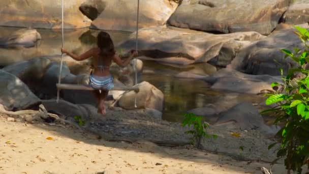 Femme insouciante sur swing dans jungle forêt vue arrière. Jeune femme se balançant dans la forêt tropicale. Montagne dans fond de forêt tropicale . — Video