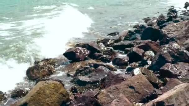 Golven van zeewater op rotsachtige strand op zomerdag. Close-up van water golven spatten op oceaan strand. Prachtige zee golven op steenachtige oever. — Stockvideo