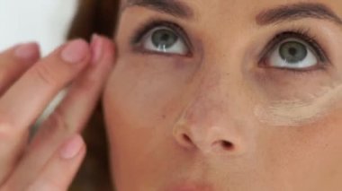 Göz çevresindeki deri kapatıcı krem uygulayarak makyaj sanatçısı. Yakın kadar profesyonel güzellik stüdyosu kadında oluşturur. Visagiste makyaj yüz genç kadın için yapıyor.