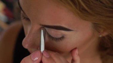 Göz kapağı moda model üzerinde kaptırdın uygulamak için makyaj fırça kullanarak Visagiste. Makyaj sanatçısı makyaj gözler güzellik stüdyosu genç kadın için yapıyor. Güzellik ve stil kavramı.