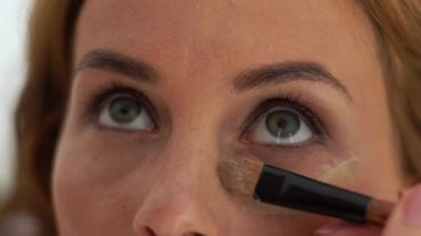 Kozmetik fırça kullanarak makyaj modeli göz çevresi cilt tonu krem uygulayarak Visagiste. Yakın kadar makyaj yüzü ise Güzellik okulunda eğitim yapıyor sanatçı makyaj.