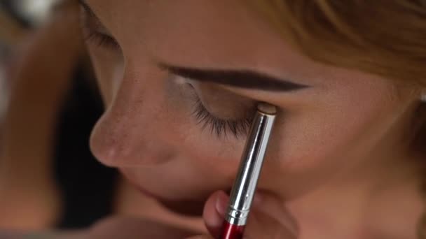Καλλιτέχνης μακιγιάζ κάνει καπνιστή μάτια make up για όμορφη γυναίκα. Κοντινό Visagiste εφαρμογή μάτια μακιγιάζ. Επαγγελματική visage incosmetic στούντιο. Έννοια της μόδας και του στυλ. — Αρχείο Βίντεο
