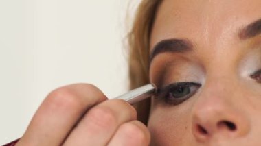 Seksi makyaj gözleri için çekici kadının işi makyaj sanatçısı. Sinema sanatçısı için makyaj uygulanması visagiste kapatın. Kozmetik Studio profesyonel sima. Moda ve güzellik sektörü.