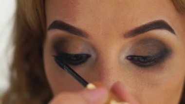 Makyaj gözlerini kapatın. Rimel uygulamak Visagiste. Kadın kirpik makyaj Studio üzerinde uygulama rimel ise yüz. Güzel kadın için akşam makyaj.
