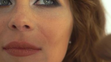 Genç kadın için makyaj yüz için kozmetik fırça kullanarak makyaj sanatçısı. Kadının yüzünde makyaj uygulanması visagiste kapatın. Moda ve güzellik kavramı.