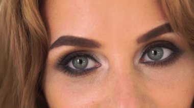 Kameraya bakarak glamour makyaj ile kadın gözlerini kapatın. Pürüzsüz bir cilt ve moda makyaj yüzünü kameraya poz olan kadın. Portre güzel kadın.