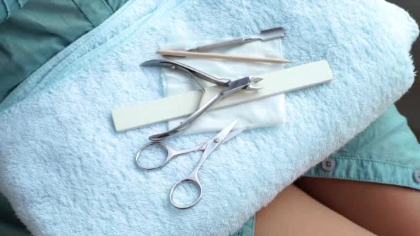 Strumenti di manicure per manicure professionale o a casa sdraiato su un asciugamano. Forbici per unghie per tagliare unghie, pinzette per cuticole, bastone di legno, spintore per cuticole e lima per unghie. Utilizzando manicure set . — Video Stock