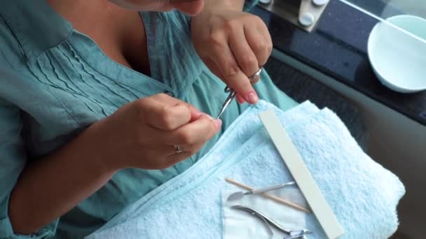 Donna con forbici manicure per cuticola tagliata e limatura unghie con lima per unghie mentre manicure a casa. Chiudete. Casa manicure e concetto di cura delle unghie . — Video Stock